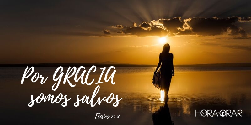 Mujer caminando en la playa cerca al mar con el sol que se pone Efesios 2:8