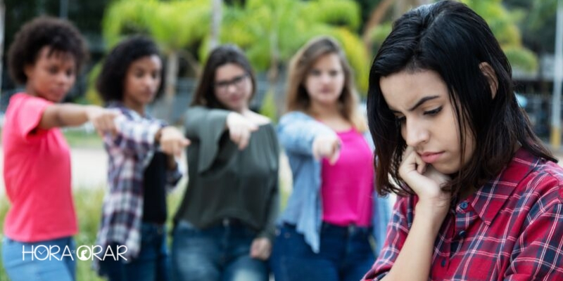 Niñas burlándose de otra niña apuntando el dedo