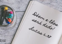 Caderno aberto com texto escrito Lucas 6:38