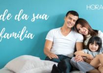 familia, pai, mãe e filha sentados no chão parede azul