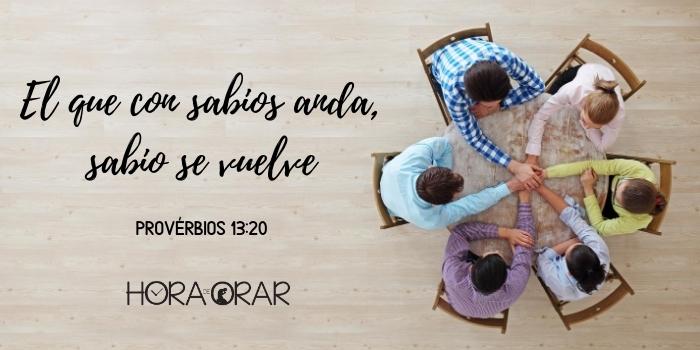 Grupo de amigos en vuelta a una mesa, unidos con las manos. Proverbios 13:20