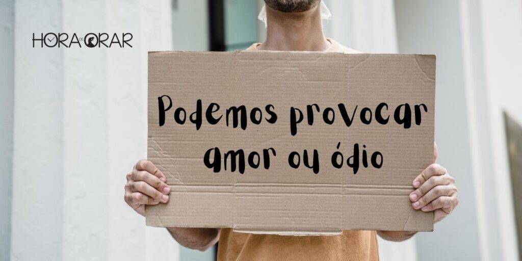 Homem segura cartaz de papelão com os dizeres: "Podemos provocar amor ou ódio"