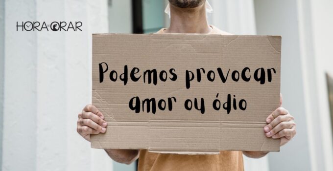 Homem segura cartaz de papelão com os dizeres: "Podemos provocar amor ou ódio"